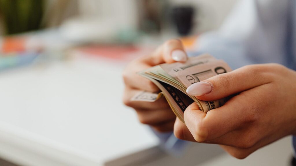 Woman's hands holding dollar bills