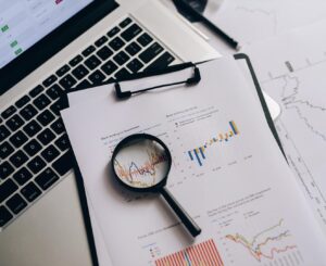 Magnifying glass over paper with graphs